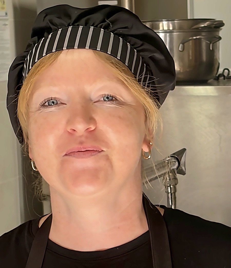 L'altra cuoca di Miri Piri, con cappello e grembiule, davanti alle pentole della cucina